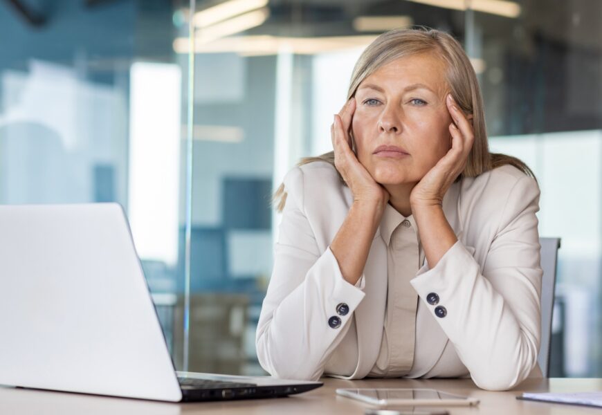 Sad unsatisfied senior woman at workplace depressed, mature business woman unhappy with achievement