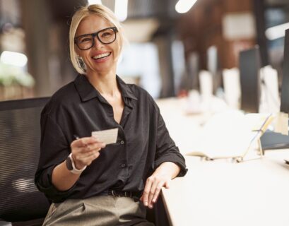 A Confident Businesswoman Smiling Brightly at Her Modern Office Desk Ready for Work and Success